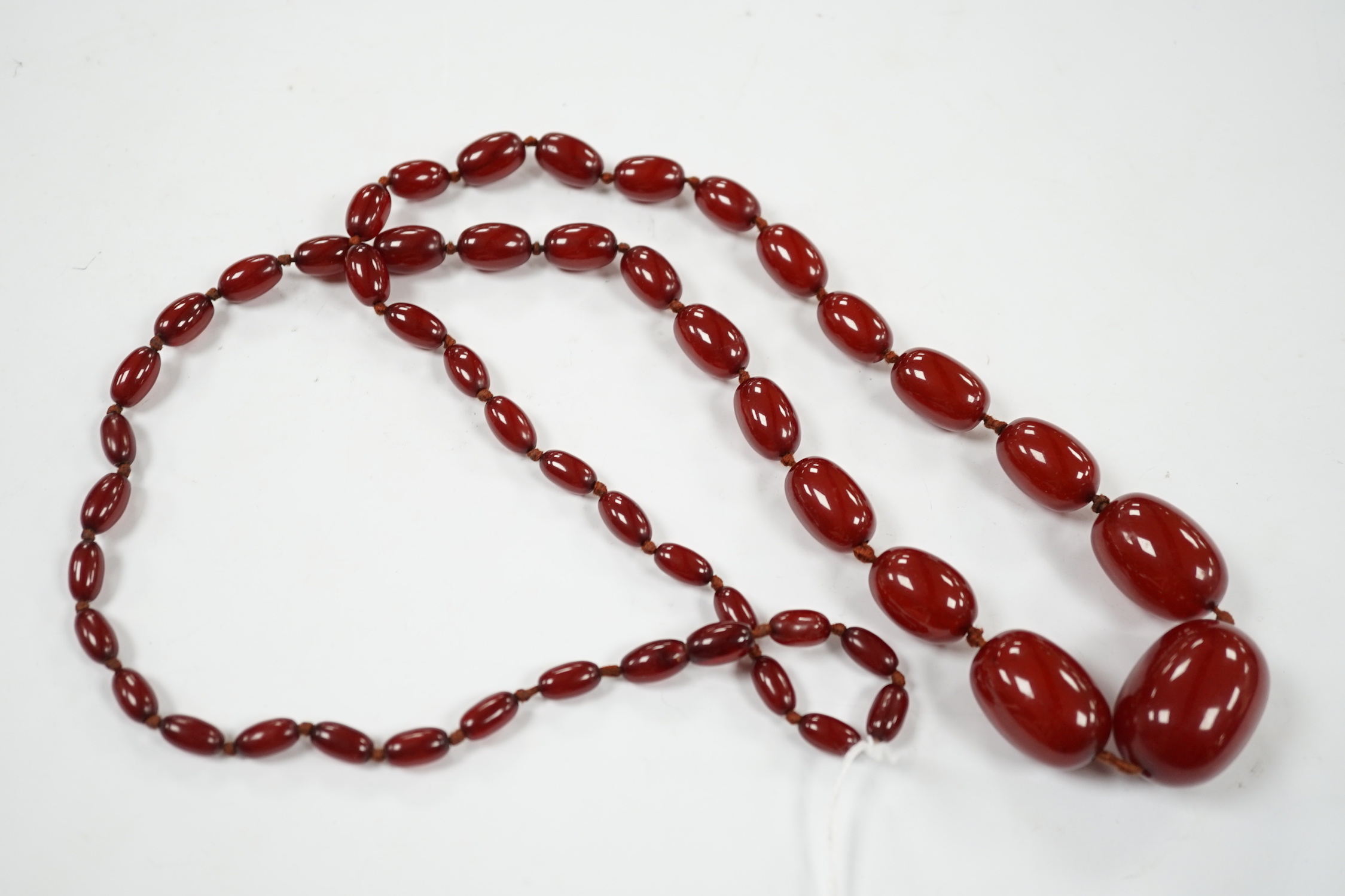 A single strand graduated simulated cherry amber necklace, 88cm, gross weight 74 grams.